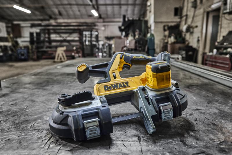 DEWALT Akku-Bandsäge auf einer Metallwerkbank in einer Werkstatt.