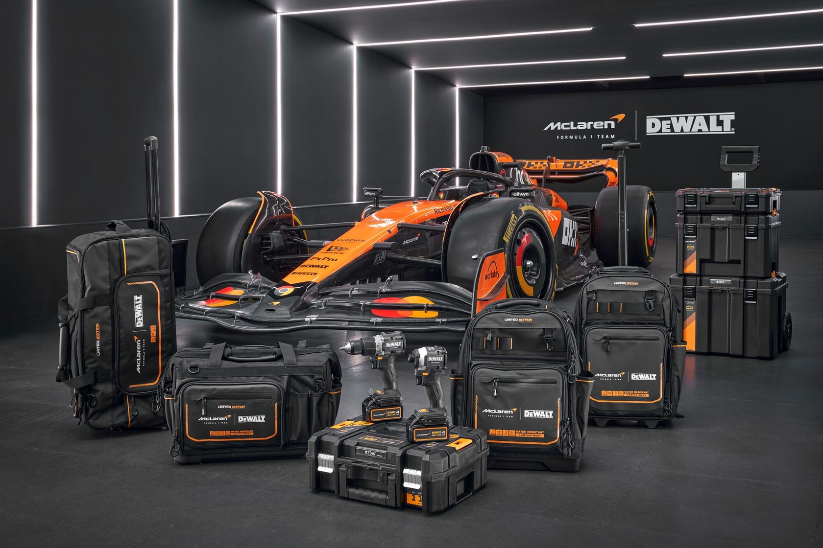 DEWALT Werkzeugtaschen und Boxen vor einem orangefarbenen Formel-1-Auto im modernen Showroom.